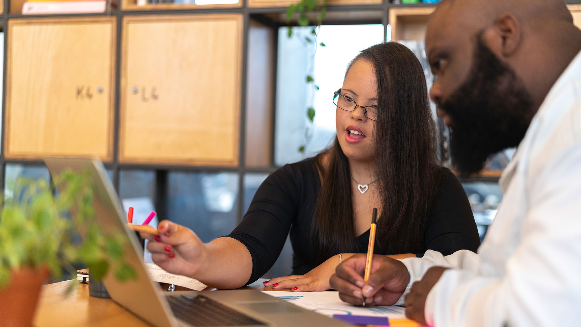 A photo of a woman with a learning disability talking to another person